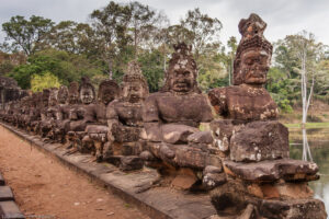 Divinità guerriere di pietra scolpita lungo il ponte sul fossato vicino all´ingresso sud di Angkor.