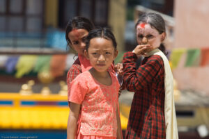 Sguardi intensi e seri negli occhi dei bambini di Kathmandu
