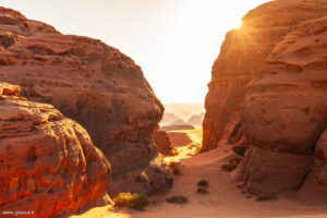 Il sole tramonta dietro le formazioni rocciose nel Wadi Bajdah, regione di Hisma, Arabia Saudita