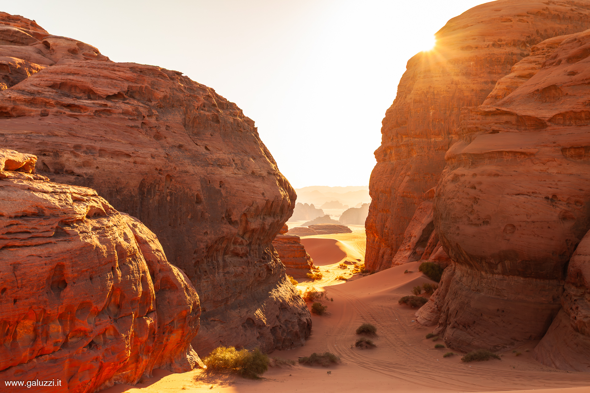 Il sole tramonta dietro le formazioni rocciose nel Wadi Bajdah, regione di Hisma, Arabia Saudita