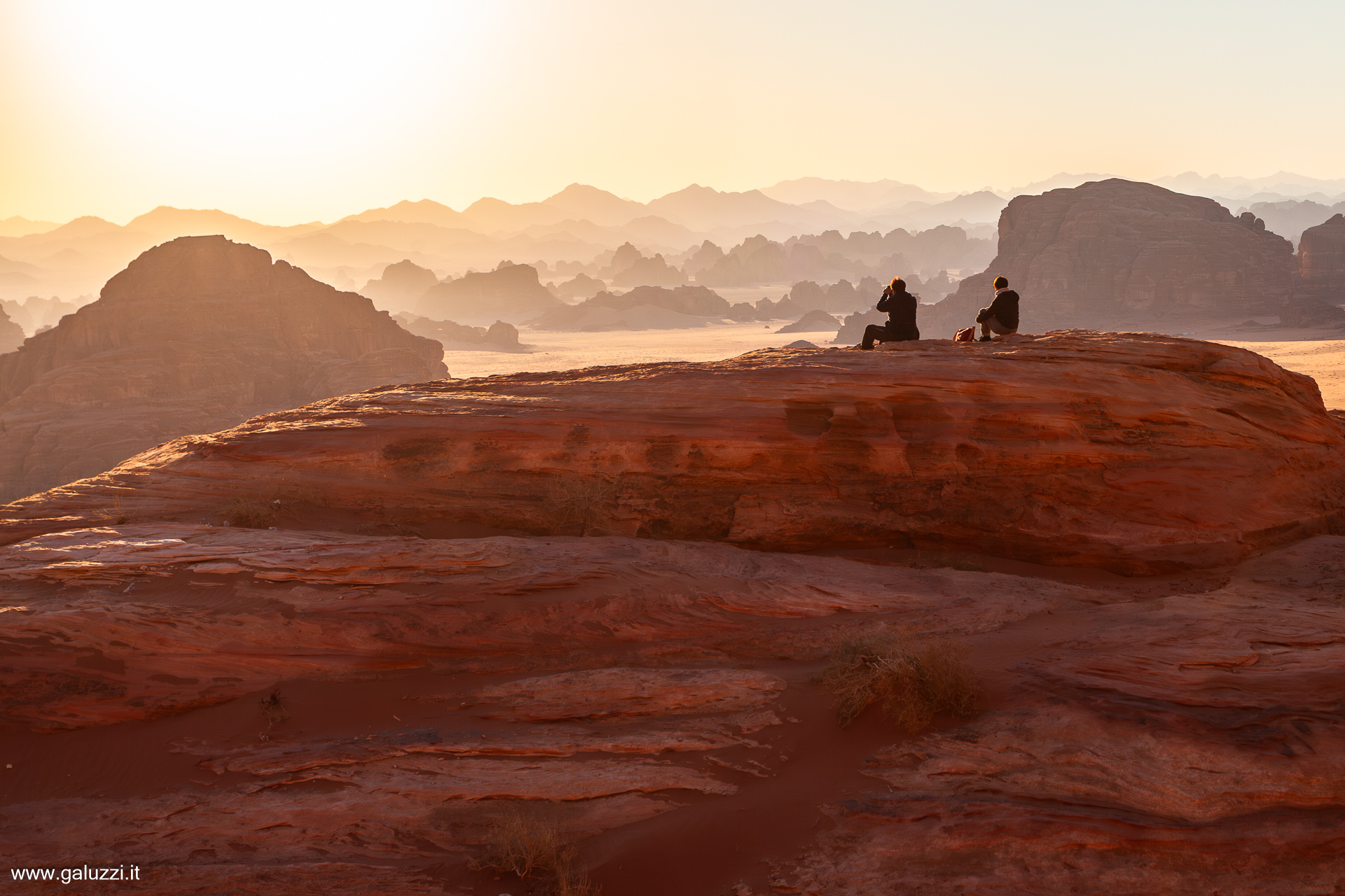 Il sole tramonta dietro le formazioni rocciose nel Wadi Bajdah, regione di Hisma, Arabia Saudita